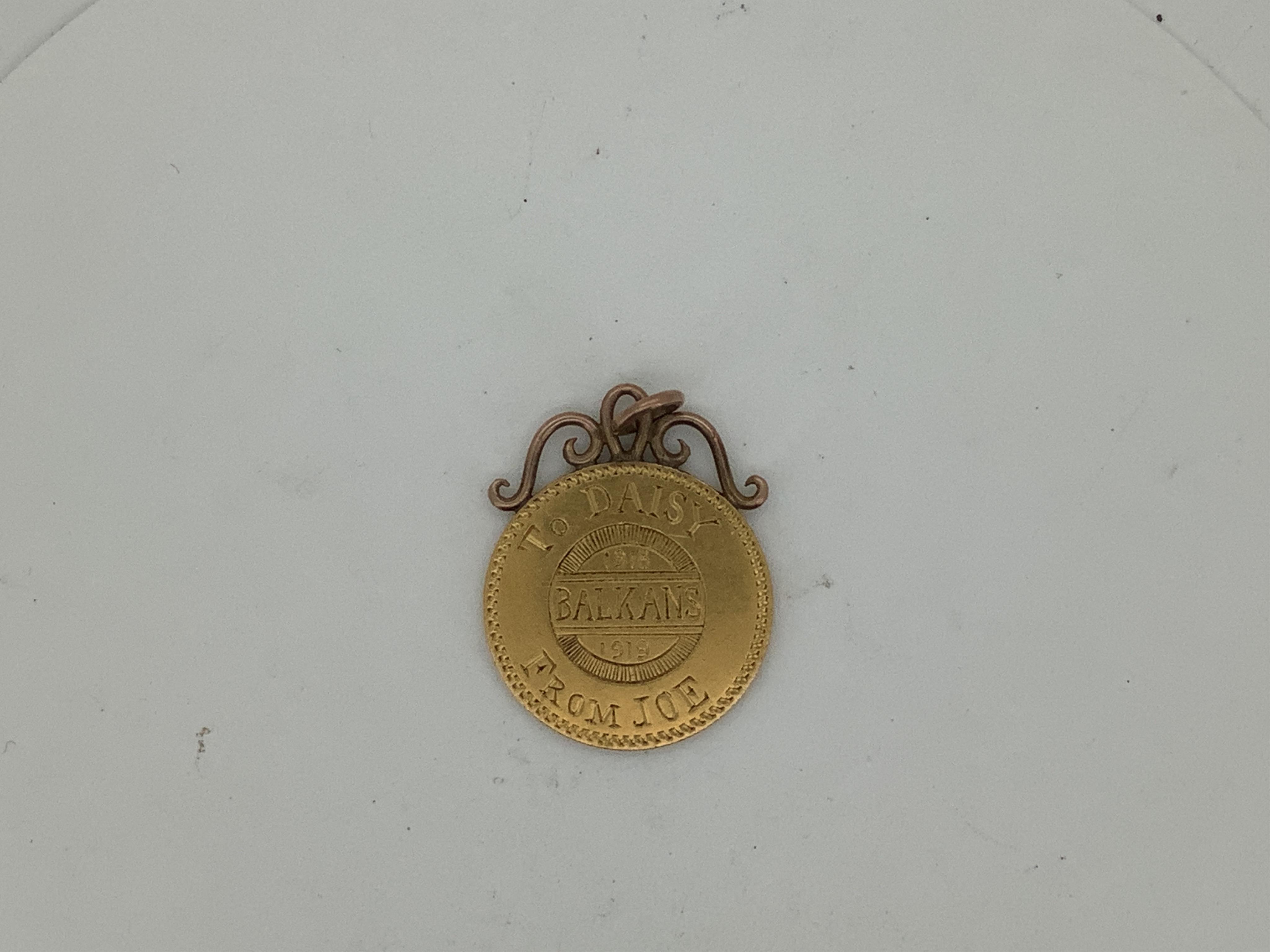 A yellow metal pendant, with engraved inscription, 'To Daisy From Joe 1918 1919 Balkans' diameter 21mm.